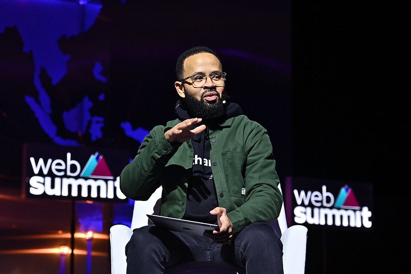 Fernando Cabral, managing director of FS-360 and Djassi Africa, sits in an armchair. Fernando is wearing a radio mic and appears to be speaking. The Web Summit logo appears in several places on the wall behind Fernando.