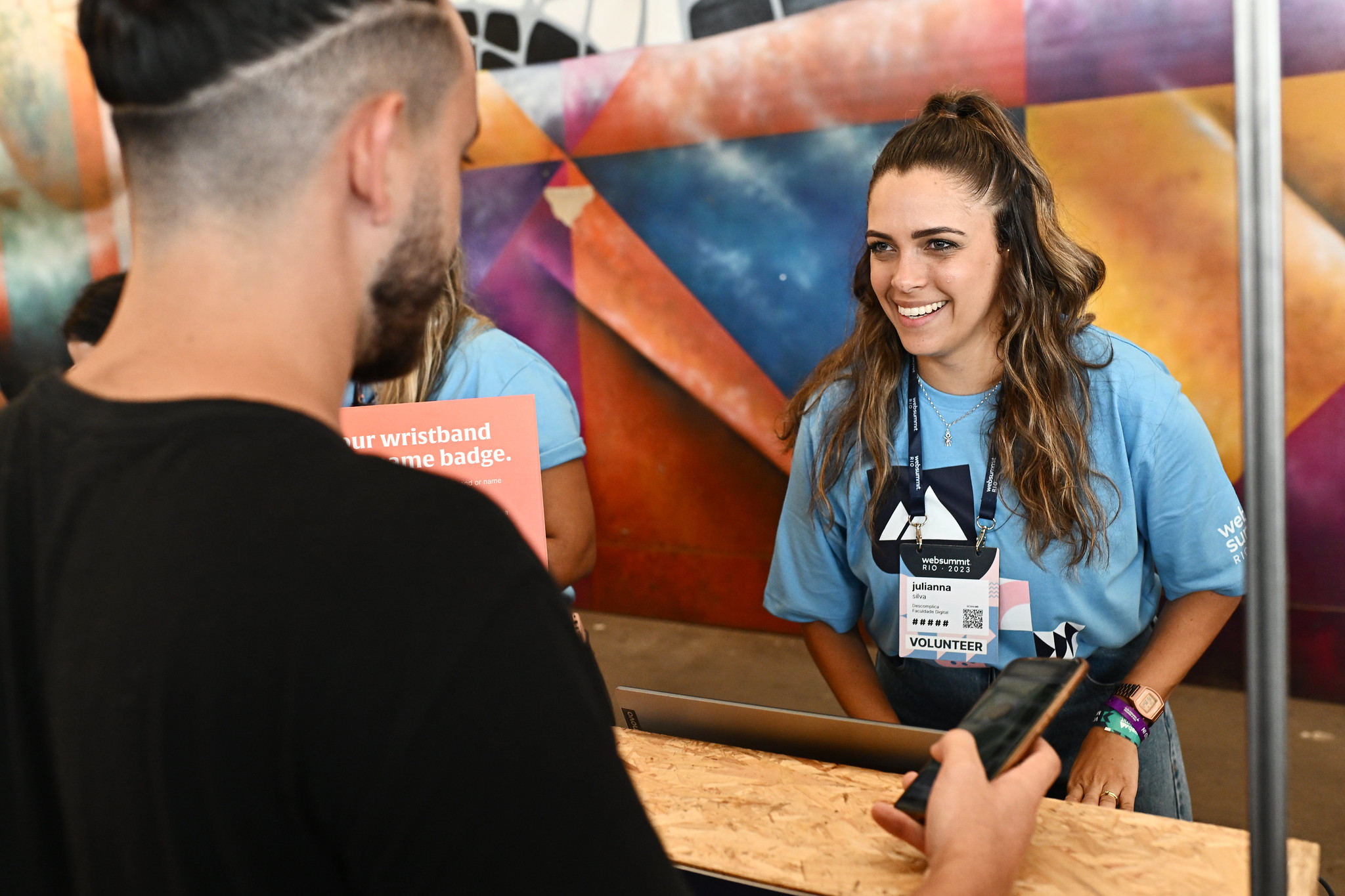 A volunteer talks to an attendee ahead of the opening night of Web Summit Rio 2023 at Riocentro in Rio de Janeiro, Brazil.