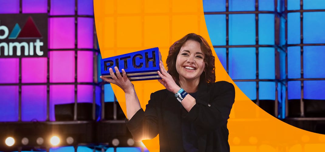 PITCH winner Ana Robakidze, founder and CEO, Theneo, on Centre stage at Web Summit 2022. Ana is smiling and holding up the PITCH trophy.