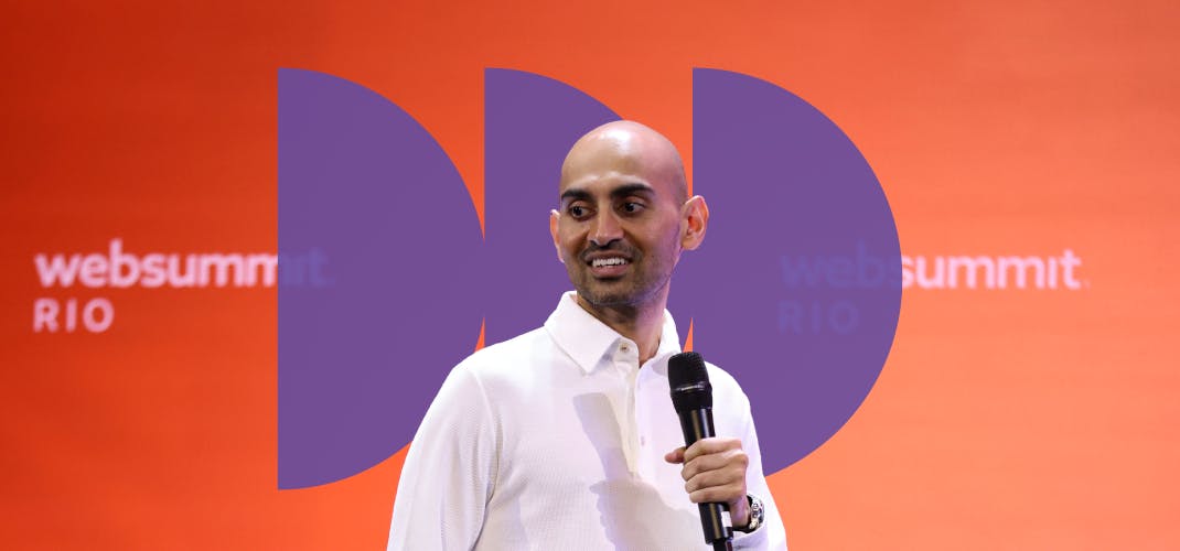 An image of Neil Patel, founder of NP Digital. Neil is holding a microphone. The Web Summit Rio logo appears twice on a wall behind Neil.