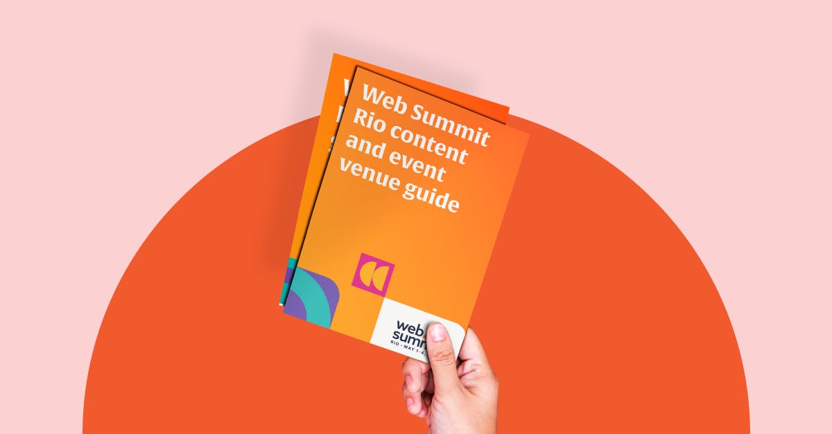 A hand holding a leaflet thats reads ‘Web Summit Rio content and event venue guide’